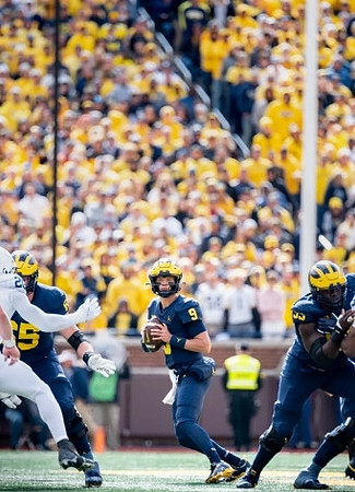 Zak Zinter (65), J.J. McCarthy (9), and Olusegun Oluwatimi (55)